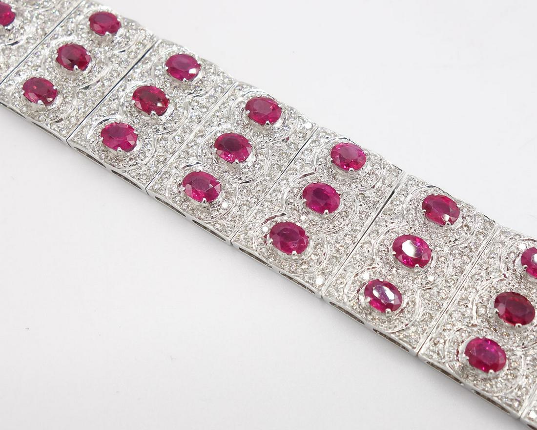 18K White Gold Wide 9+twt Ruby 9+twt Diamond Bracelet: An 18K white gold wide natural ruby and diamond bracelet with oval faceted rubies and round bead set diamonds in a concentric pattern. The rubies in this bracelet are approximately 9.75 twt and the ro