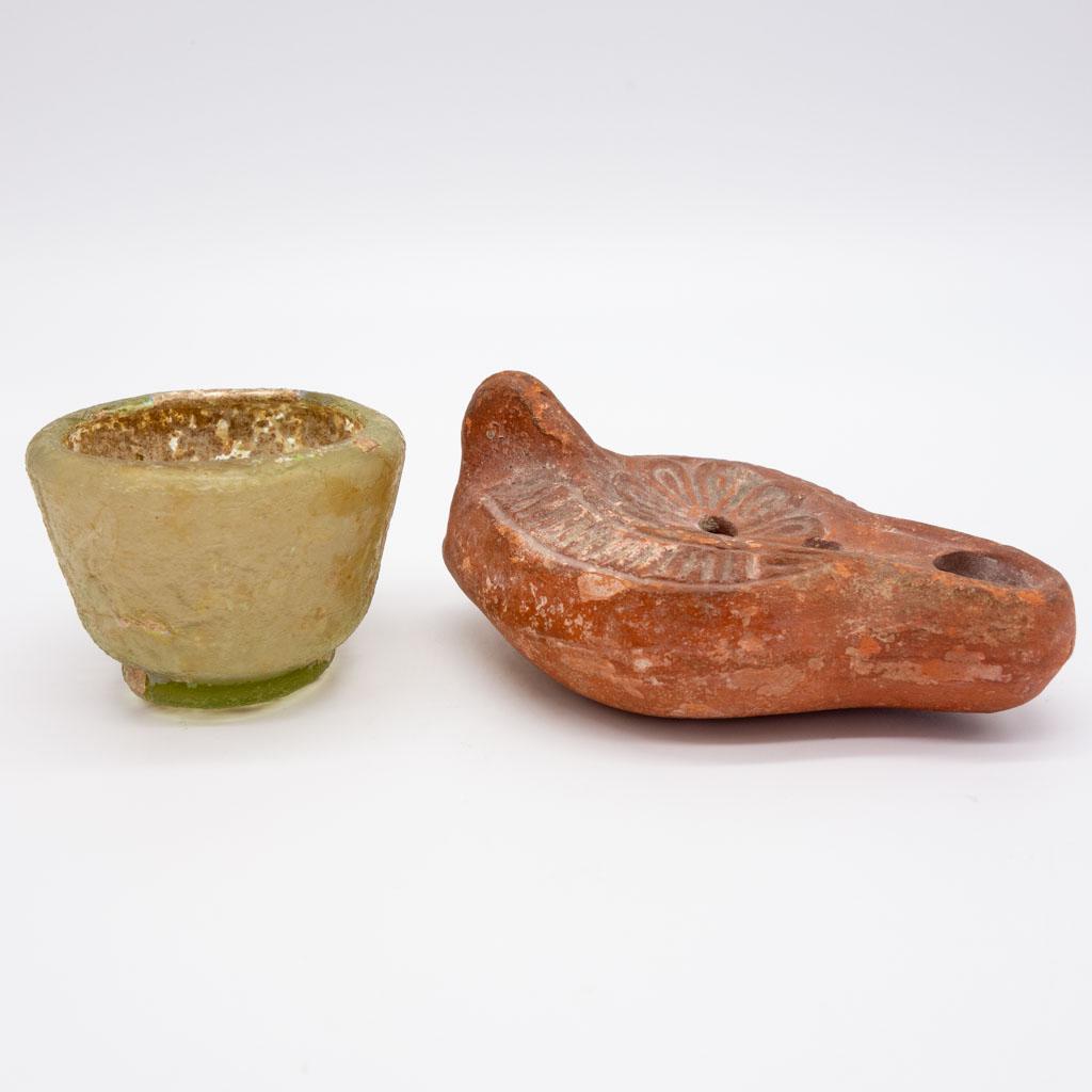 Antique Roman Glass Cup and Pottery Oil Lamp: This is an antique Roman glass cup and a slipper-form pottery oil lamp. Each has old numbered museum inventory tags. Cup 2.5 x 1 3/4", lamp 4.5 x 2.75 x 2"