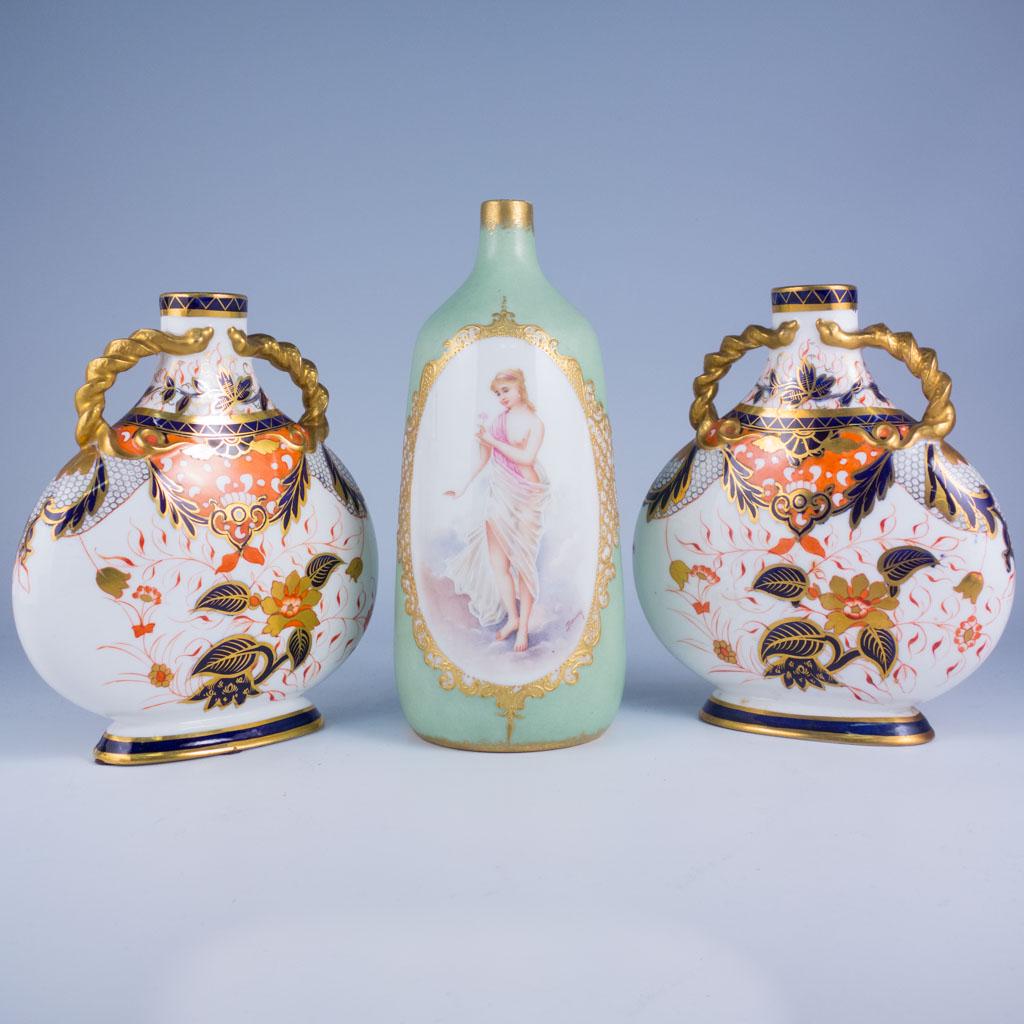 Antique Nude Limoges Portrait Bottle & Imari Flasks: This lot is of three antique porcelain vases dating to the early 20th century. The two imari pattern moon flasks were produced by Davenport of London. The French Limoges vase features a draped nude. T