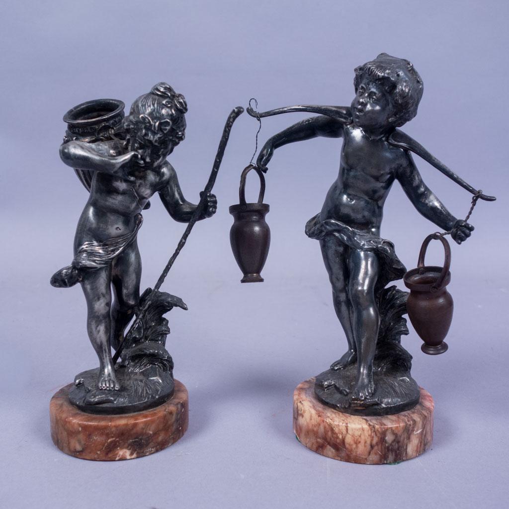 Pair Antique Silverplated Rococo Figural Statues: Two silverplated miniature Rococo statues on marble bases. One is of a boy carrying water buckets over his shoulders. The other is of a girl with a walking stick and a basket on her back. 9" tall
