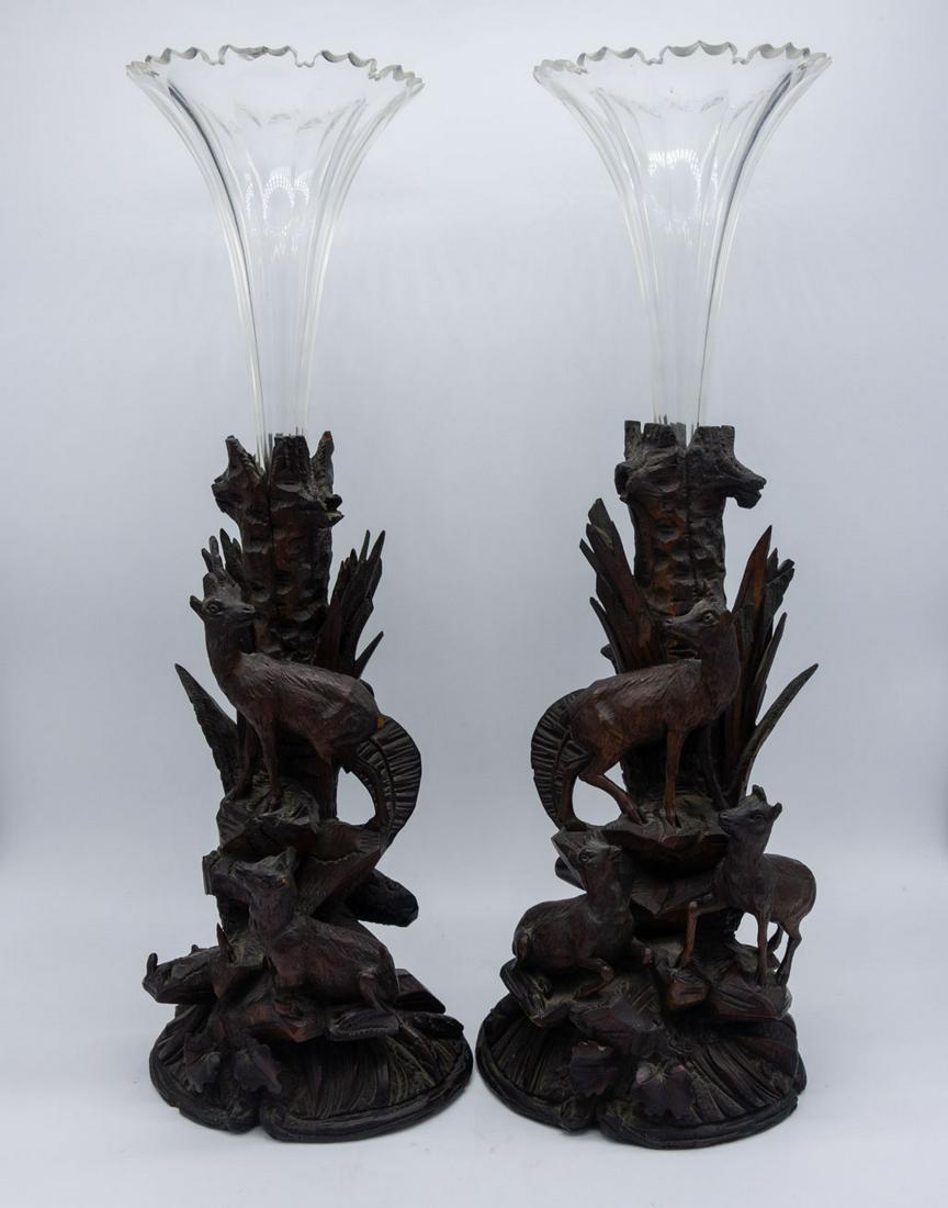 19c Black Forest Carved Walnut Glass Insert Vases 18": These 19th century black forest carved walnut vases feature a scene with mountain goats scaling a peak. The wooden bases are accompanied by fluted clear glass inserts. 18" x 7"