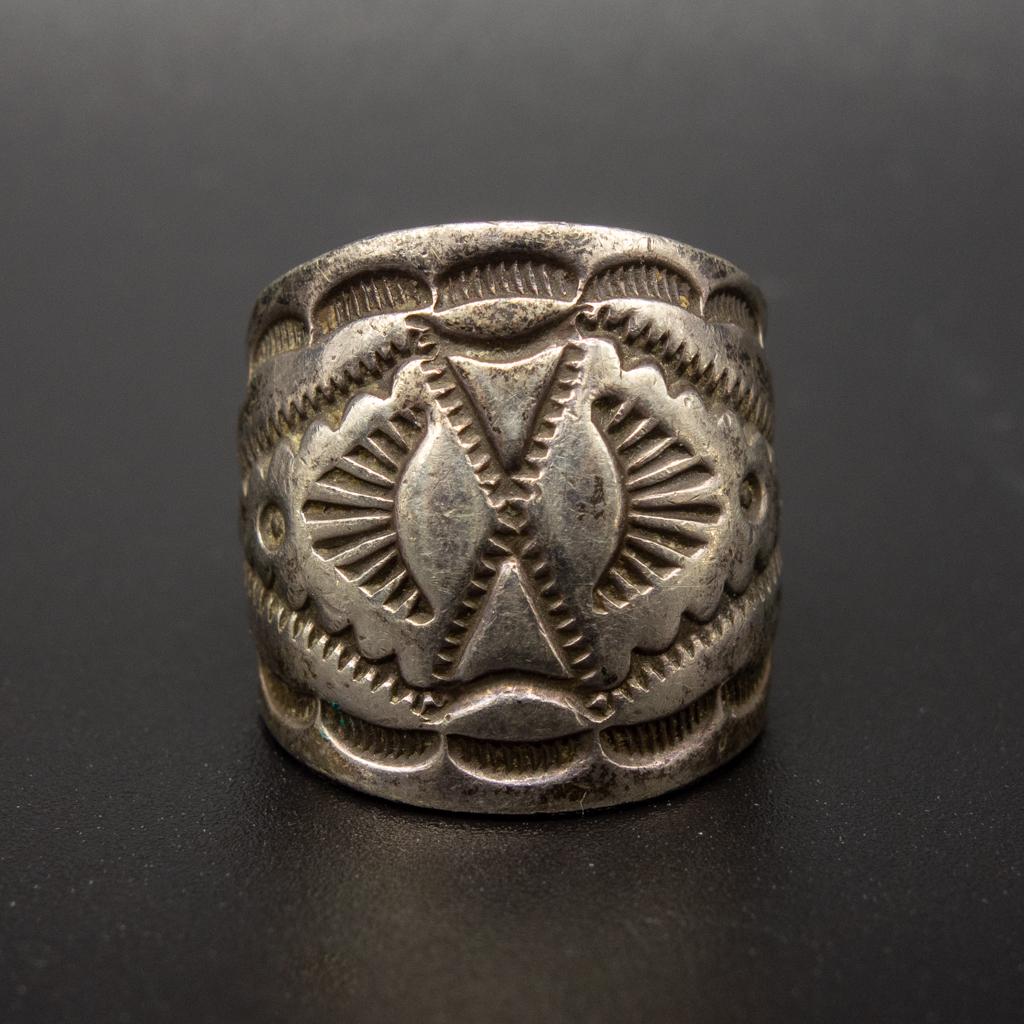 Native American Pawn Navajo Sterling Silver Ring WTF: This is a Native American pawn Navajo ring rendered in fine sterling silver with stamped designs. Size: 5.75 US. Weight: 7.2g. Width: 5.3-19.3mm