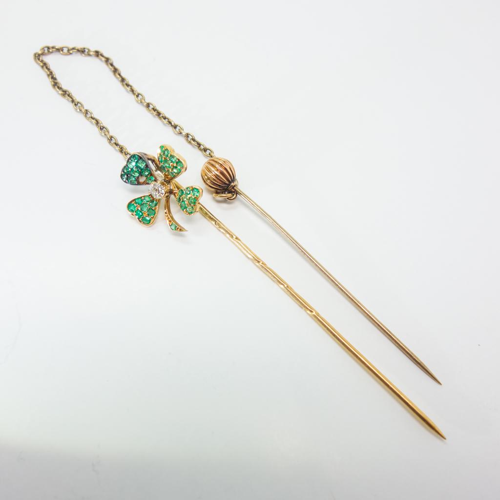 Gold Emerald and Diamond Four Leaf Clover Stickpin: This stickpin is made in 14K yellow gold with old European cut emeralds and diamond in a four leaf clover design. The clover is chained to another pin that looks like a scepter. Both pins with chain 8