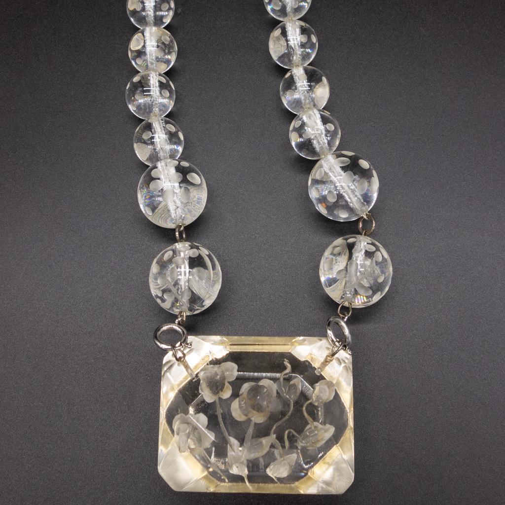 Joyce Francis Large Carved Floral Pendant Necklace: This is a carved lucite beaded pendant necklace with a floral motif by Joyce Francis. 18" necklace length. The pendant is 2 1/2 x 1 7/8"