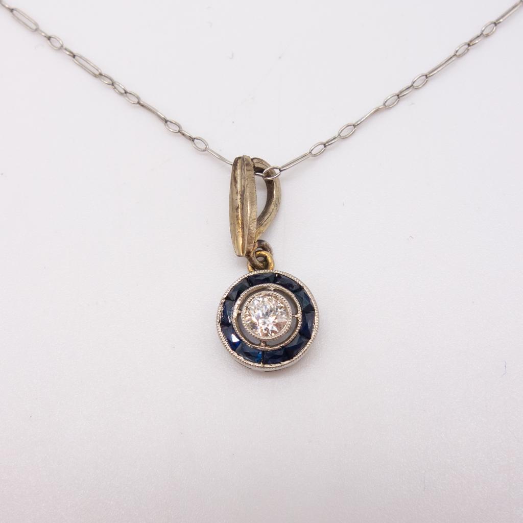 Vintage Platinum Diamond Sapphire Pendant Necklace: This is a vintage Art Deco platinum pendant necklace featuring a halo of sapphires surrounding an Old European cut diamond. SI clarity and HI color. The chain is 18" long and the pendant diameter is 3