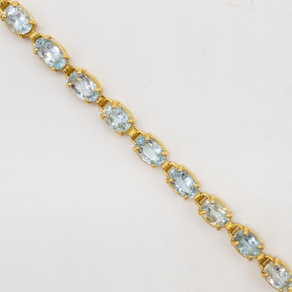 Vintage 14K Gold Aquamarine Tennis Bracelet: This is a vintage ladies tennis bracelet rendered in fine 14K yellow gold. The bracelet features 18 oval faceted aquamarines. The bracelet length is 7 1/4" and the width is 6mm. The total weight is 12