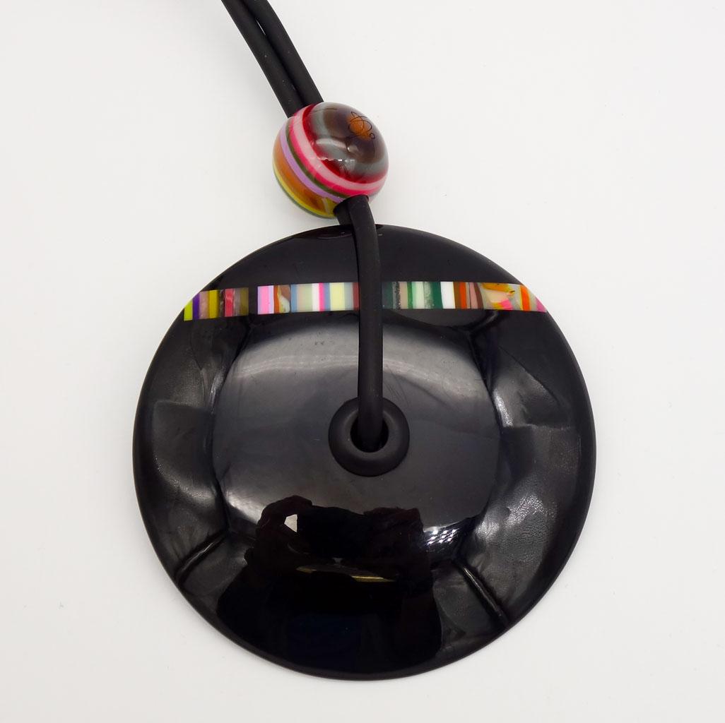 Sobral Pop Art Resin Lariat Style Black Disc Pendant with Colorful Stripes: This is a vintage resin necklace from Brazilian designer Carlos Sobral. The black disc lariat style necklace is accented with a colorful stripes. The necklace length is 30". The pendant is 3 1/2" diam