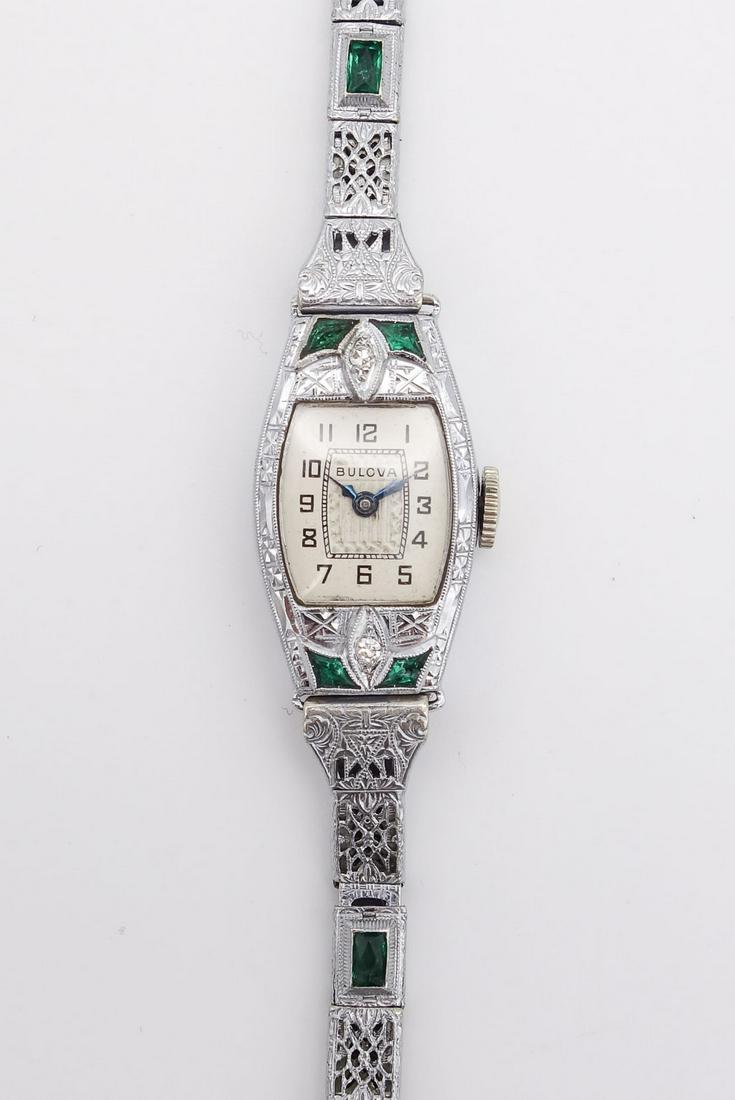 Antique Art Deco 14K White Gold Filigree Diamond Emerald Bulova Ladies 15J Wristwatch: This is an antique Swiss ladies Bulova 15 jewel wristwatch featuring an Art Deco 14K white gold filigree case accented by single cut diamonds and emeralds. The filigree band is not gold. The case is 2