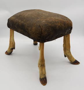 Antique Adirondack Camp Deer Leg Leather Foot Stool: This is an antique leather topped foot stool atop four taxidermied deer legs from an Adirondack Mountain camp. 16" H x 21 1/4" x 14 1/2". 