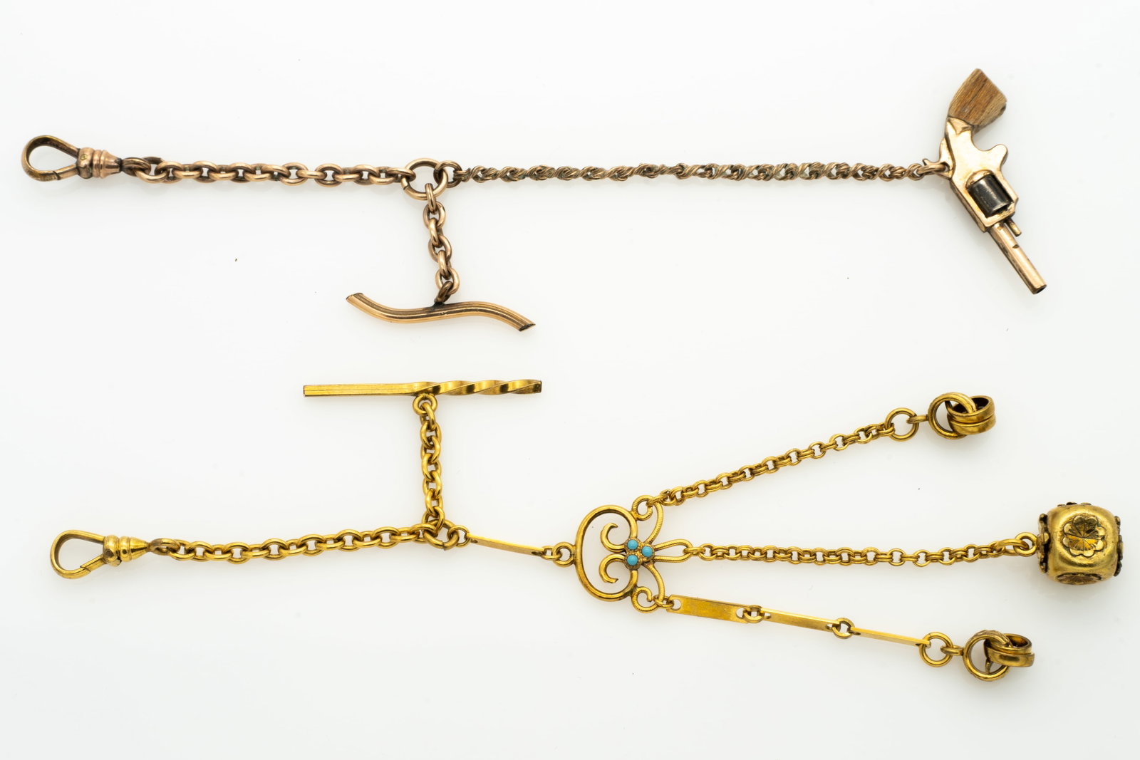 Two Fancy Antique Watch Chains with Fobs Including Revolver: Lot 67 Two Fancy Antique Watch Chains with Fobs Including Revolver Revolver Chain Length: 5.65 in. Other Length: 5.6 in. 14.5 g