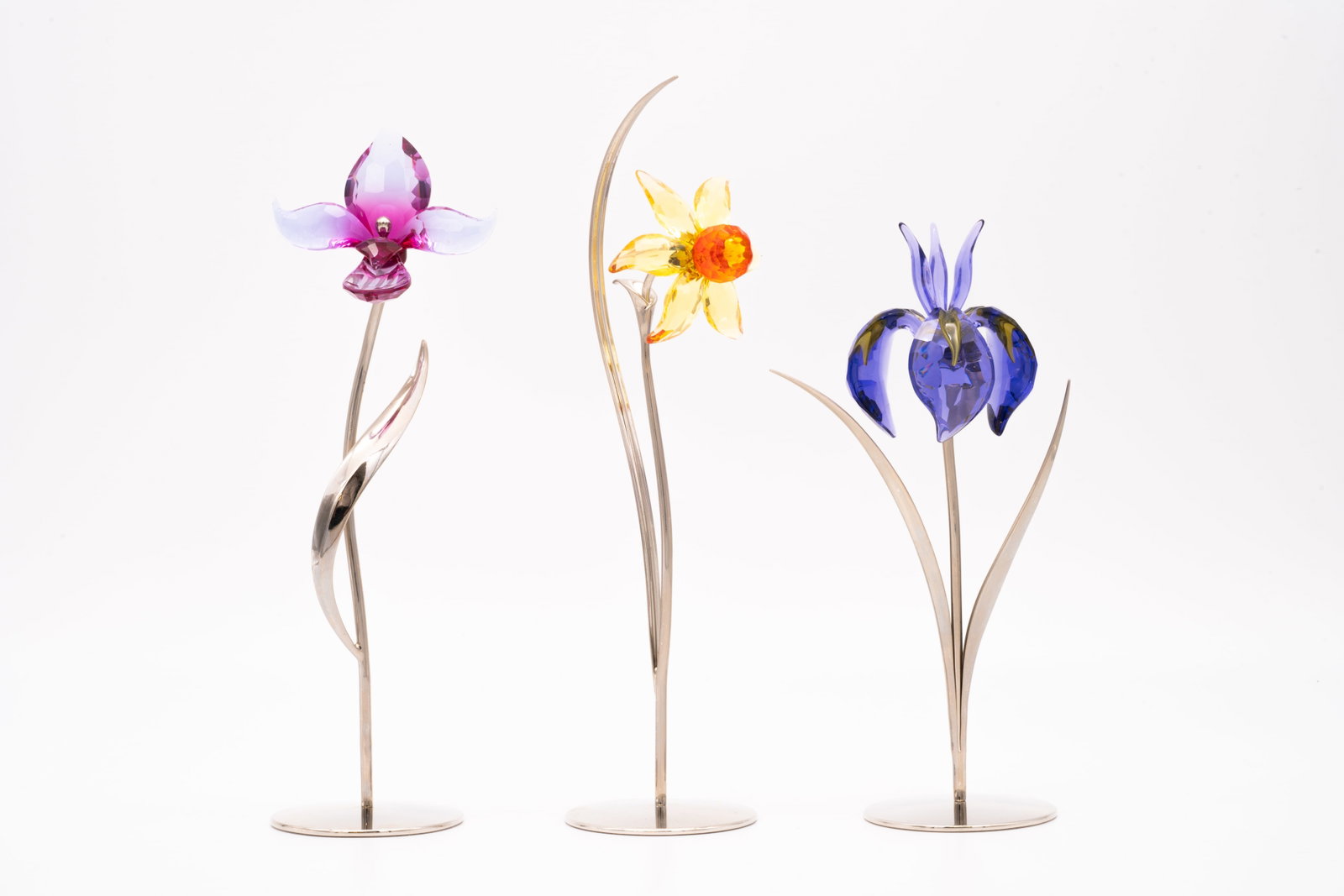 3 Swarovski Flowers, Fuchsia Rain 681542, Light Topaz 848448, Blue Violet 848449: Lot 143 3 Swarovski Flowers, Fuchsia Rain 681542, Light Topaz 848448, Blue Violet 848449 Fuchsia Rain 681542, Light Topaz 848448, Blue Violet 848449. Includes packaging. Tallest: 10 in. Shortest: 8 in