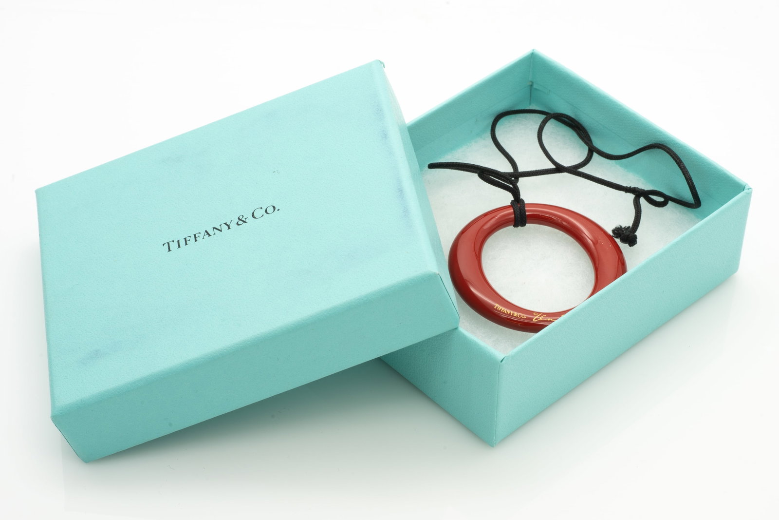 Tiffany and Co. Elsa Peretti Sevillana Red Lacquer on Japanese Hardwood Necklace Silk Cord 16 in.: Lot 313 Tiffany and Co. Elsa Peretti Sevillana Red Lacquer on Japanese Hardwood Necklace Silk Cord 16 in. Includes Box. This Pendant features red lacquer over Japanese hardwood. Inscribed: TIFFANY[amp