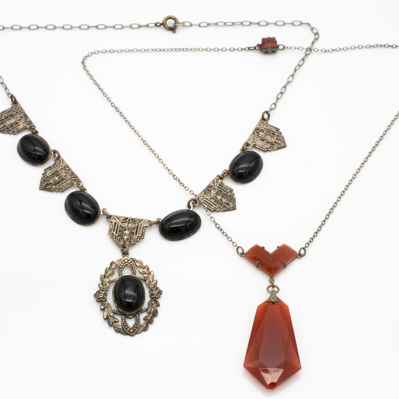 Ornate filigree art deco lavalier necklaces carnelian and Onyx: Lot 108 Ornate filigree art deco lavalier necklaces carnelian and Onyx Dimensions: Longer Chain (Carnelian): 16.5 in. Carnelian pendant: 1.57 x .78 x .23 in. Shorter Chain: 16 in. Weight: 25.9 g
