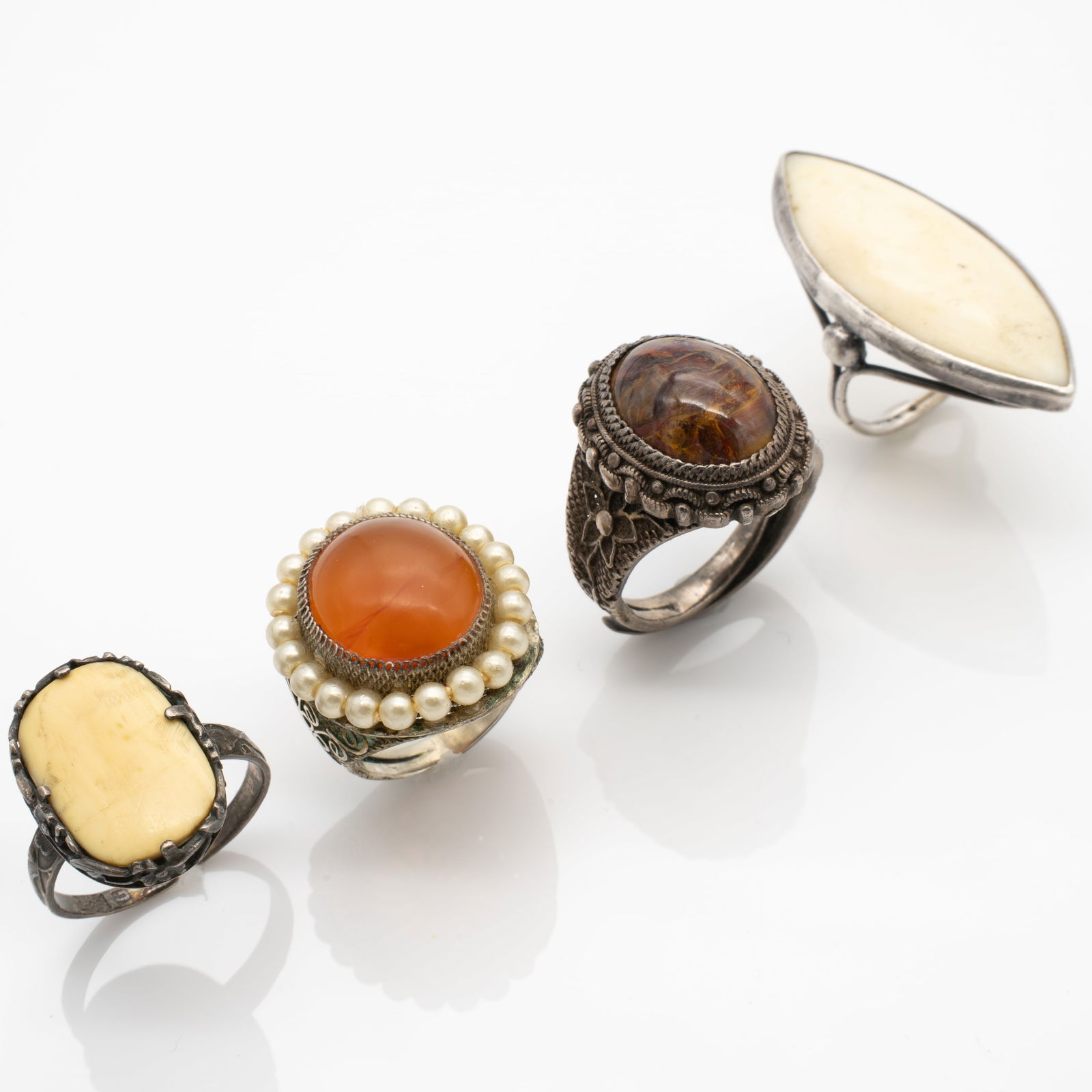 Lot of 4 Chinese Export Silver Ornate Filigree Rings Carnelian, Bone, Hardstone: Lot 136 Lot of 4 Chinese Export Silver Ornate Filigree Rings Carnelian, Bone, Hardstone Dimensions: Elongated Bone Ring Size: 3.5, Bezel: 1.46 x .67 in. Other Bone Ring: 7.5 (adjustable), Bezel: .78 x