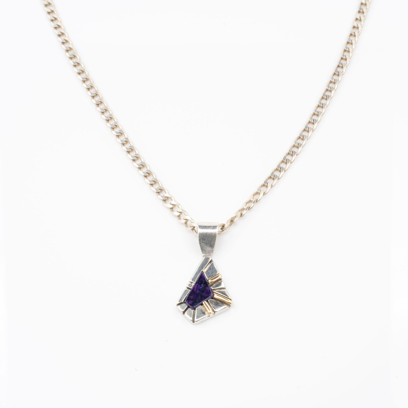 Ron Henry, Navajo, Sugilite, 14K Gold, Sterling Silver, Native American Pendant incl Chain: Lot 183 Ron Henry, Navajo, Sugilite, 14K Gold, Sterling Silver, Native American Pendant incl Chain Description: Stamped Verso: RJH Material: 14k Gold, Sugilite Dimensions: 1.35 x .66 x .24