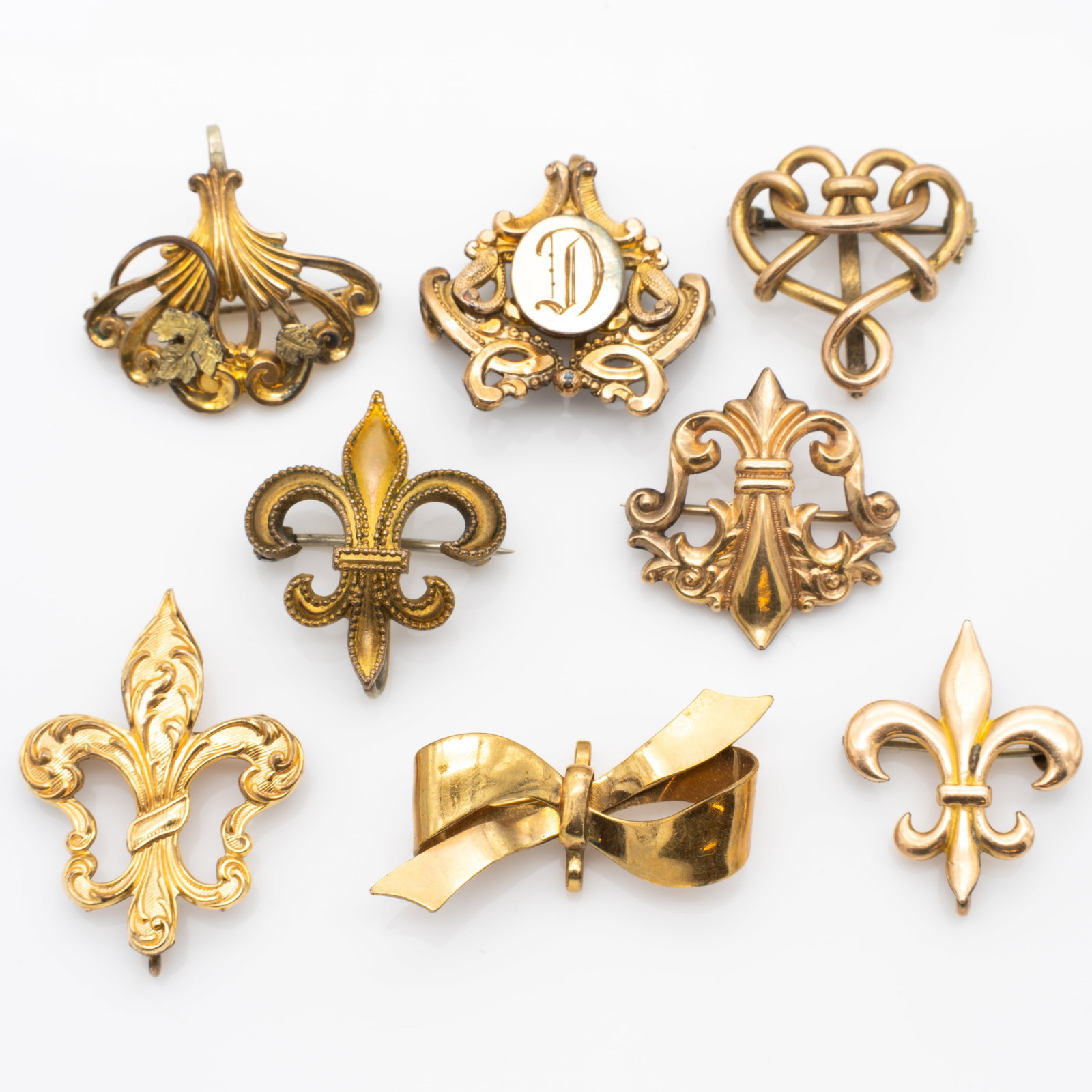 Lot of 8 Gold GF Antique Watch Pins: Lot 278 Lot of 8 Gold GF Antique Watch Pins Description: Ornate Fleur De Lis Stamped: 1/20 10KT / GOLD FILLED CT Bow Stamped: 1/20 12KT G.F. / A[ampersand]Z Dimensions: Largest: 1.43 x .84 x .4 in.