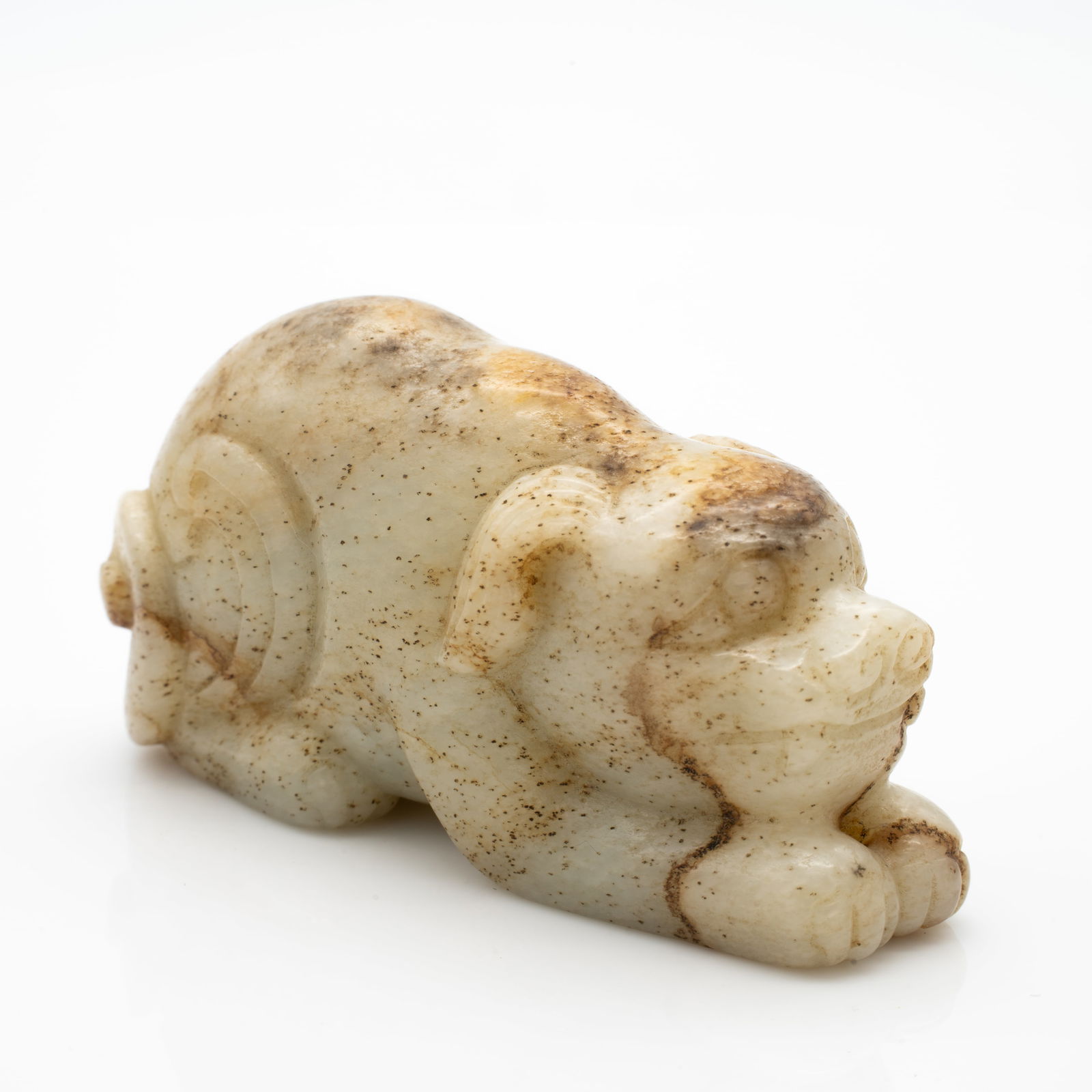 Carved Chinese Jade Figure of a Recumbent Mythical Beast: Lot 49 Carved Chinese Jade Figure of a Recumbent Mythical Beast Description: A jade carving depicting a stylized recumbent beast, shown in a crouching pose with legs tucked beneath and head tilted for