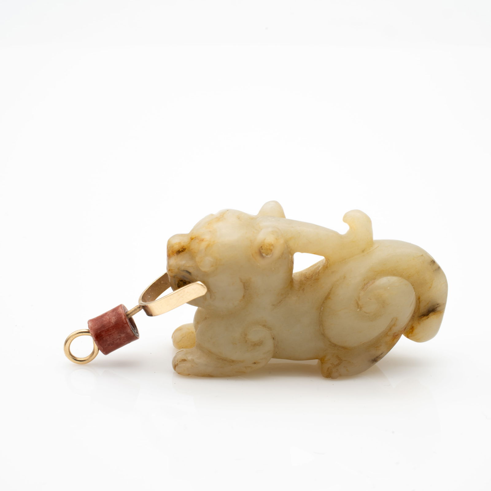 Chinese, Carved Jade Pendant of a Recumbent Beast Mounted in 14K Gold: Lot 114 Chinese, Carved Jade Pendant of a Recumbent Beast Mounted in 14K Gold Description: A small pendant carved from pale yellowish-brown Jade in the form of a recumbent mythical beast with curled