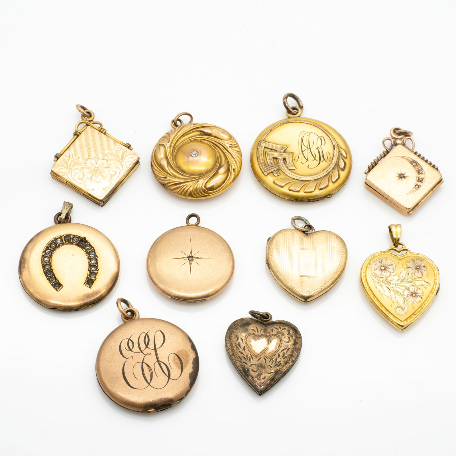 Group of 10 Antique Gold GF Lockets, Including Heart- and Round-Shaped Examples: Lot 211 Group of 10 Antique Gold GF Lockets, Including Heart- and Round-Shaped Examples Description: Designs include engraved floral motifs, applied horseshoe and starburst designs, and monogrammed f