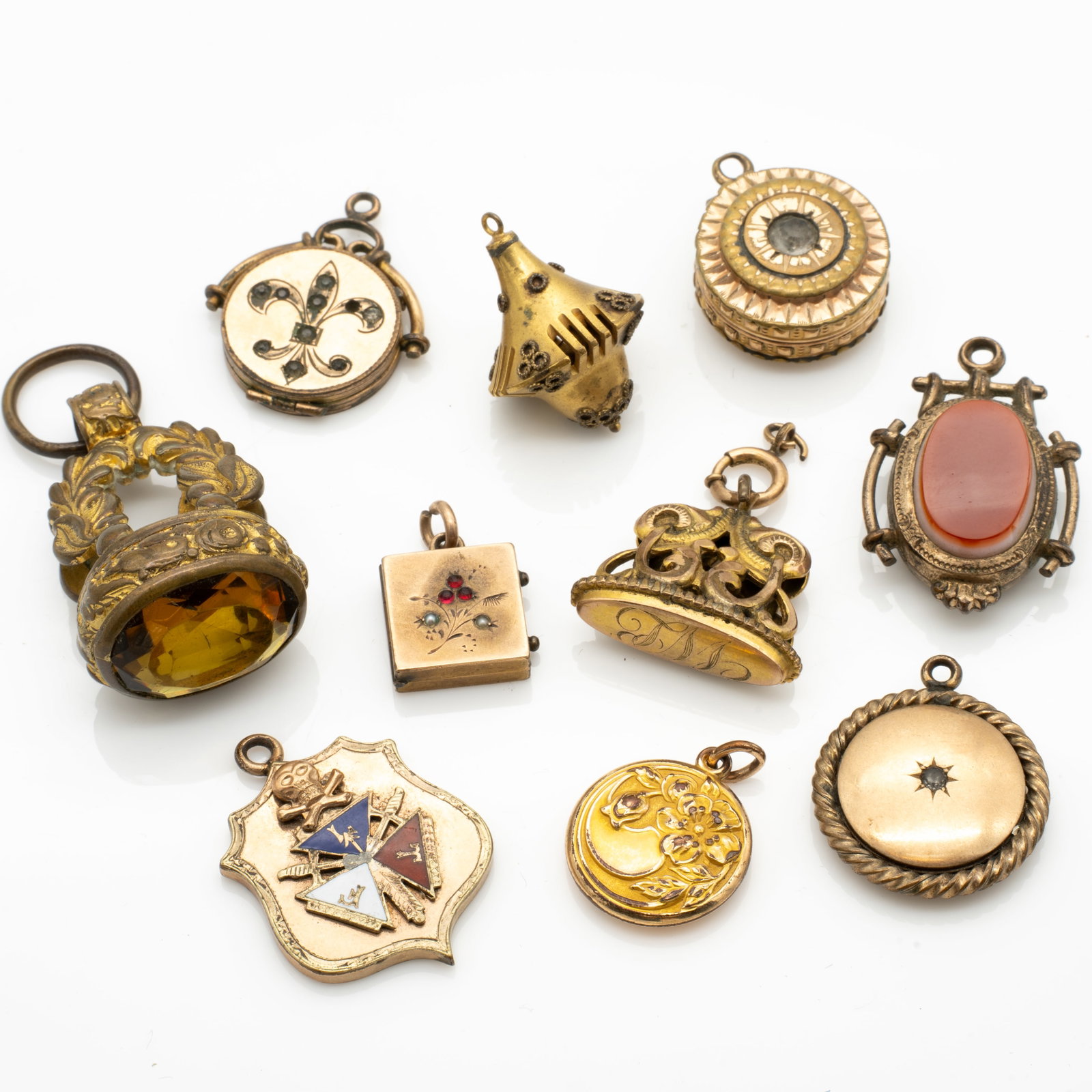 Group of 10 Antique Gold GF Pendants and Fobs with Hardstone, Gemstone and Enamel Accents: Lot 221 Group of 10 Antique Gold GF Pendants and Fobs with Hardstone, Gemstone and Enamel Accents Description: A diverse group of 10 antique charms and watch fobs. The selection includes ornate locket