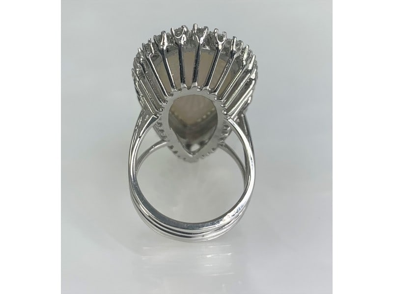 18K White Gold Opal Diamond Ring: 18K White Gold Opal Diamond Ring An eye-catching and luxurious Australian Opal ring boasting an elongated pear shaped center stone weighing 10.05 carats surrounded by a vintage halo of diamonds weighi