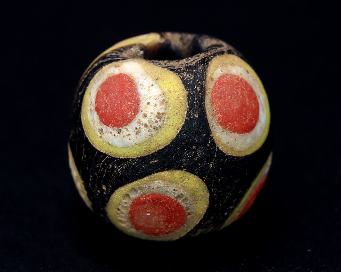 Collection of Ancient Roman Multiple Eye Glass Bead by Mr. Omar Zayd: An Ancient Roman Glass Bead Cultures/Periods: 1st-3rd Century AD Dimension: 53/64 x 3/4 inches (21x19x17mm) Findspot: Unknown Provenance: Private Collection, Family in Dubai, acquired in the 2002 from