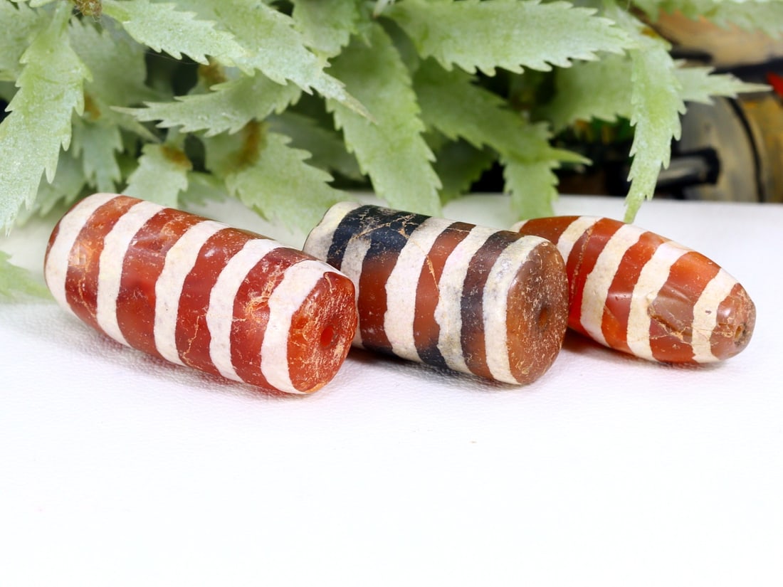Three Antique Vintage Indo Tibetan Etched Carnelian dZi Beads: 23.5x11mm Weight: 54 carat (Before Packing) Thousand Planet Auction House Season 5: Ten2Go Antique Beads Collection Auction. A bargain hunter's, fixer-upper's, and pack-rat's dream come true! Our Ten2