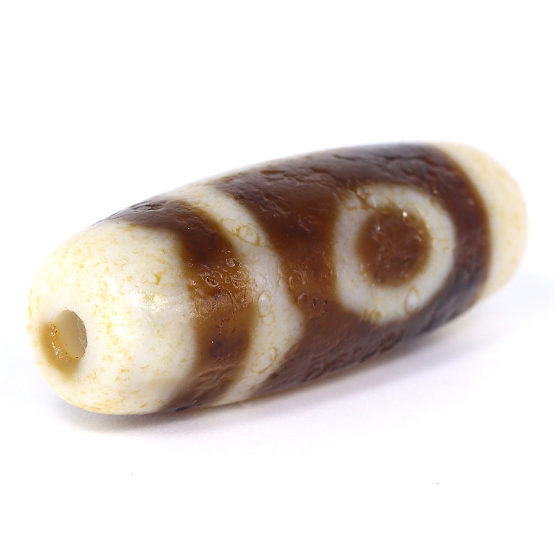 Tibetan Etched Agate Dzi Bead: An Emblem of Modern Chinese Craftsmanship (Within 10 years): Dimension: 29x11mm Rarity Level: Moderately Rare Given its recent Chinese origin, this Tibetan agate dzi bead showcases the blend of traditional Tibetan designs with contemporary crafting techniques. 