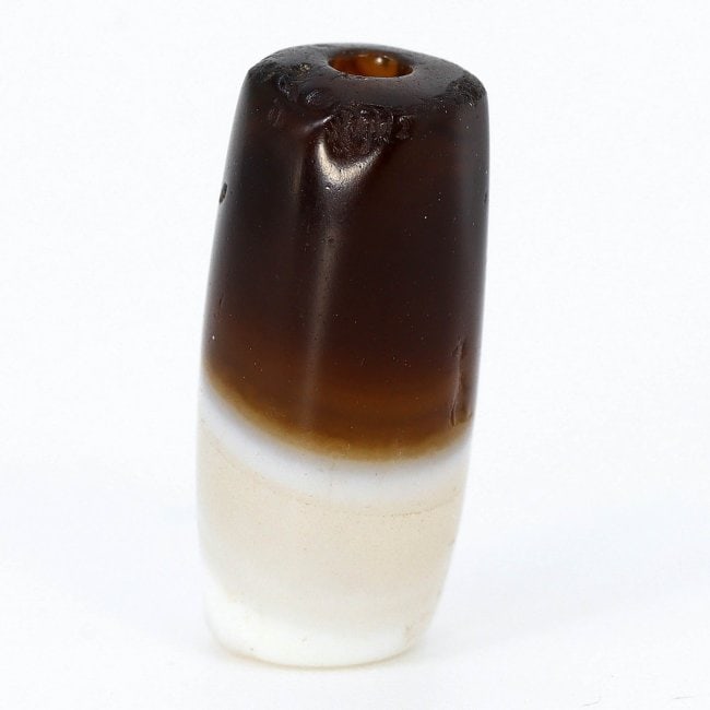 Pristine Himalayan Silk Road Banded Agate Chung dZi Bead Circa 1500-500 BC: Dimension: 16.7x7.8mm Introduction: Journey through the ancient trade routes with this pristine banded agate bead from the Himalayan Silk Road, harking back to a period between 1500 and 500 BC. The ri