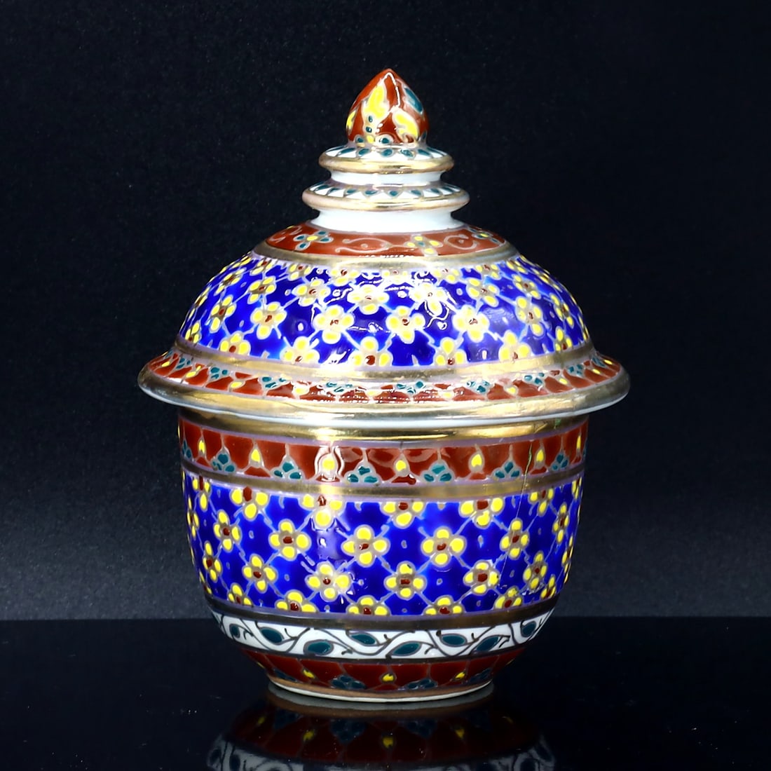 Floral Motif Porcelain Bowl with Lid: Thailand Folk Art Influence: Dimension: 9x8 cm Weight: 192 gram Introduction: This porcelain sugar bowl, embellished with a rich red base and vibrant yellow accents, carries the warmth of European folk art. The dainty floral moti