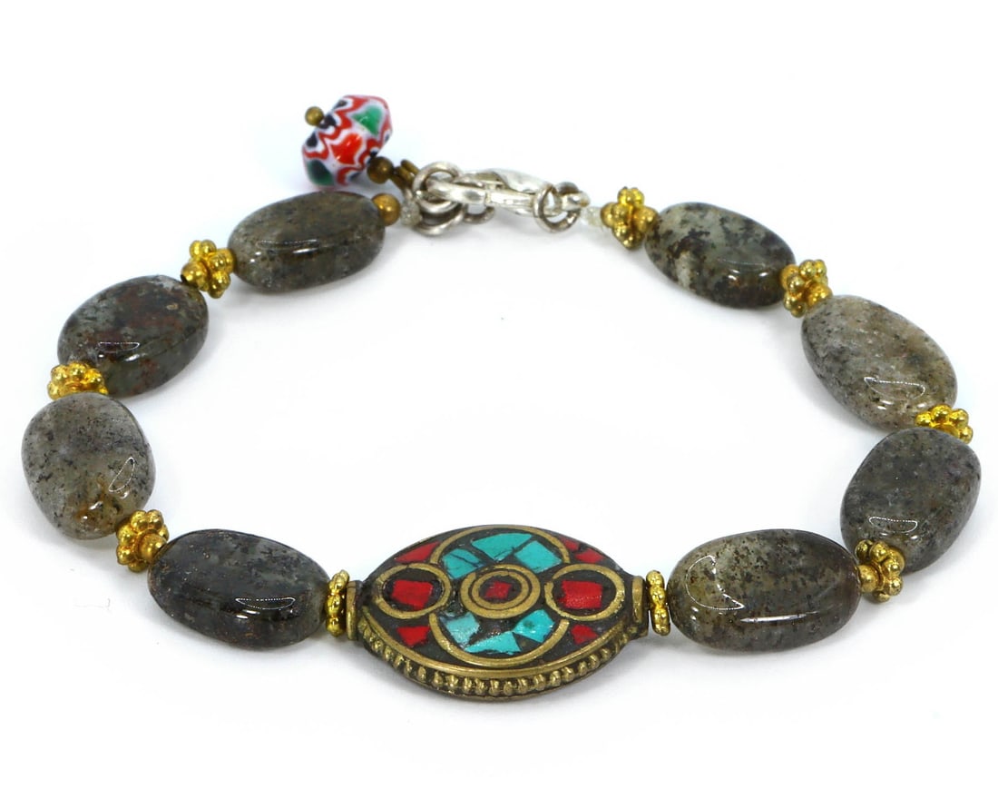 Tibetan Prayer and Chevron Beads Bracelet: A Collage of Cultural Heritage: Dimension: 8" inches Weight: 13gram Introduction: This exquisite bracelet weaves together the spiritual resonance of Tibetan prayer beads with the geometric precision of chevron beads, punctuated by t