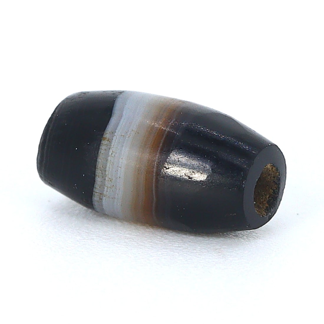 Ancient Tibetan Chung dZi Bead: An Artifact of Spiritual Significance (Ancient Tibetan Era): Dimension: 7x4mm Rarity Level: Highly Rare Considering its origins in the heart of ancient Tibet and its distinctive single stripe design, this bead stands as a testament to the deep-rooted Tibetan tr