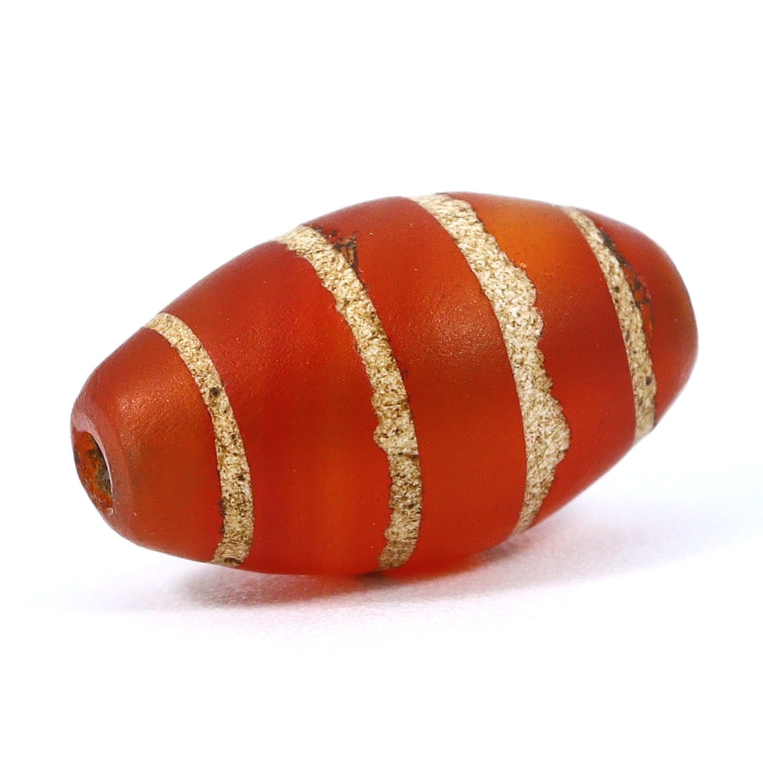 Ancient Etched 4 Stripes Carnelian Bead: Relic from the Silk Route (Medieval Period): Dimension: 11x6mm Rarity Level: Highly Rare Originating from the Silk Route area, especially the Tibetan/Himalayan regions, this etched carnelian bead serves as a testament to the rich trade and cultu