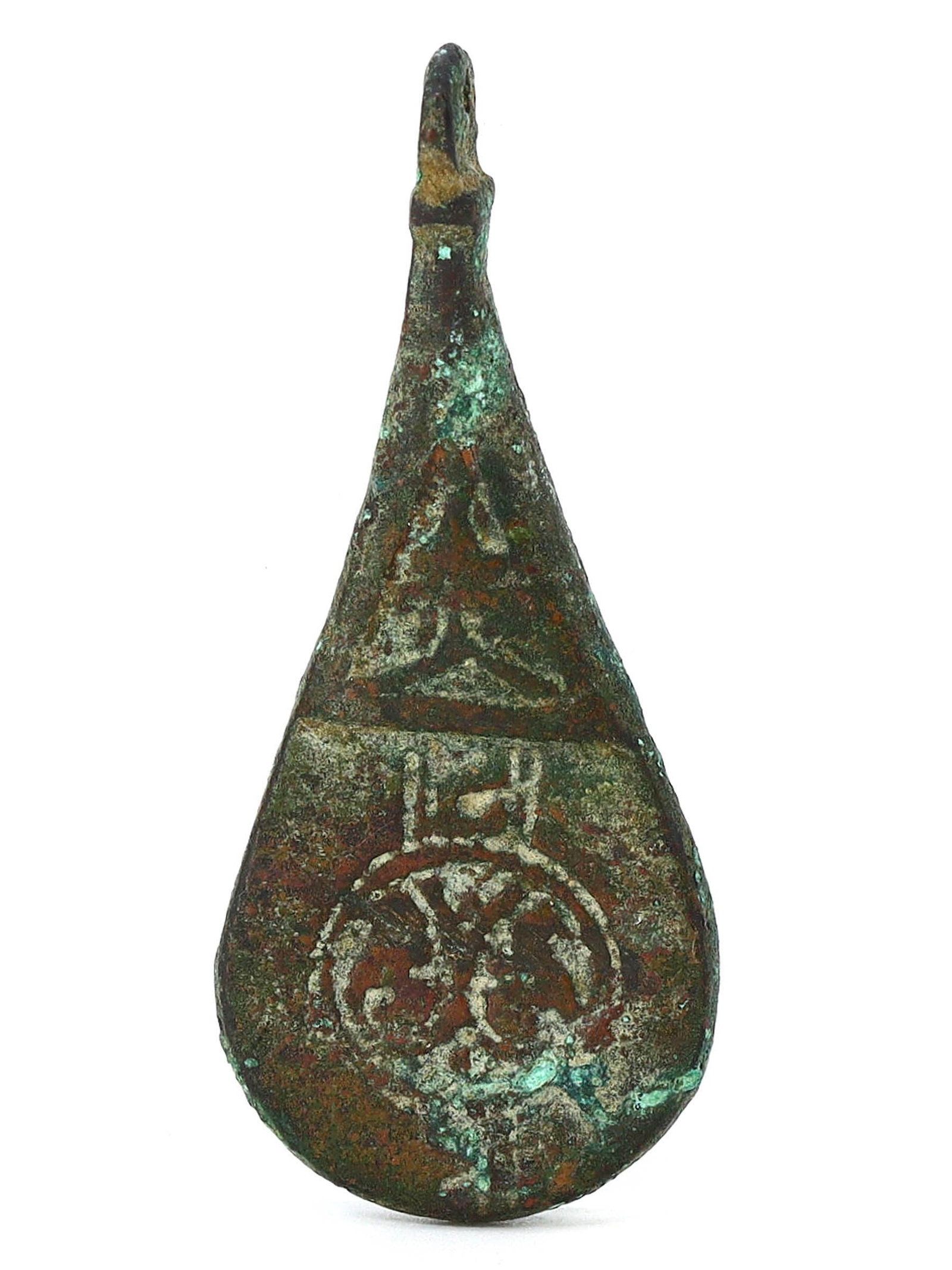 Classical Period Bronze Locket with Inscribed Symbols (600-400 BC): The bronze locket, dating from the Classical Period (600-400 BC), measures 5.5 cm by 2.5 cm (2.17 inches by 0.98 inches). Its surface is adorned with inscribed symbols that may have served as personal