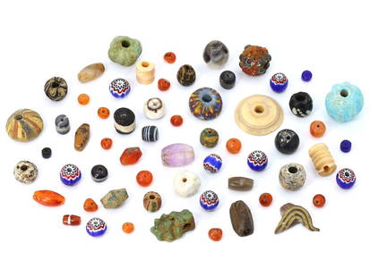 Historical Mosaic and Faience Beads - A Portal to Ancient Worlds: This lot offers a curated collection of 60 pieces, size range 6 - 25mm each, each bead and amulet serving as a miniature portal to the ancient worlds, from Egypt to the Indus Valley. The round carneli