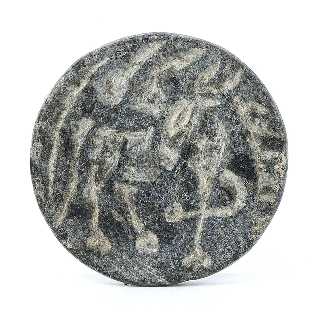 Pre-Achaemenid Black Stone Ibex Carving, Circa 1000-550 BC: This black stone carving, with a diameter of 1.38 inches (3.5 cm), features an ibex, which was a significant motif in the pre-Achaemenid period, spanning from 1000 to 550 BC. This era predates the est