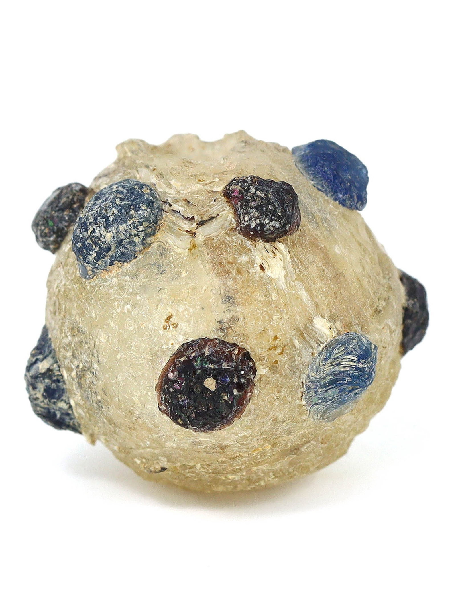 Islamic Glass Bottle with Applied Prunt Decoration, Islamic Era: This small glass bottle, featuring applied prunt decoration, is a representation of the Islamic era's glass artistry. Measuring just 2 cm in height and 1.5 cm in diameter (approximately 0.79 x 0.59 in
