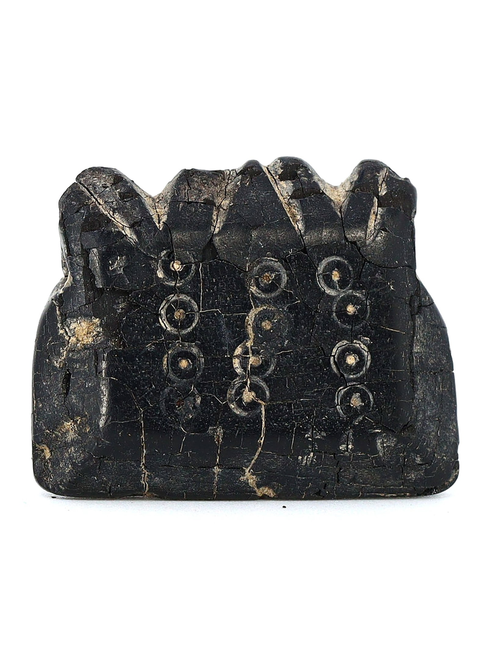 Nishapur Jet Amulet with Protective Dot-in-Circle Motif (9th–10th Century): This ancient amulet, excavated in Nishapur, Iran, dates back to the 9th–10th century. It measures 3x2 cm or approximately 1.18x0.79 inches and is crafted from jet. The amulet features a dot-in-circl