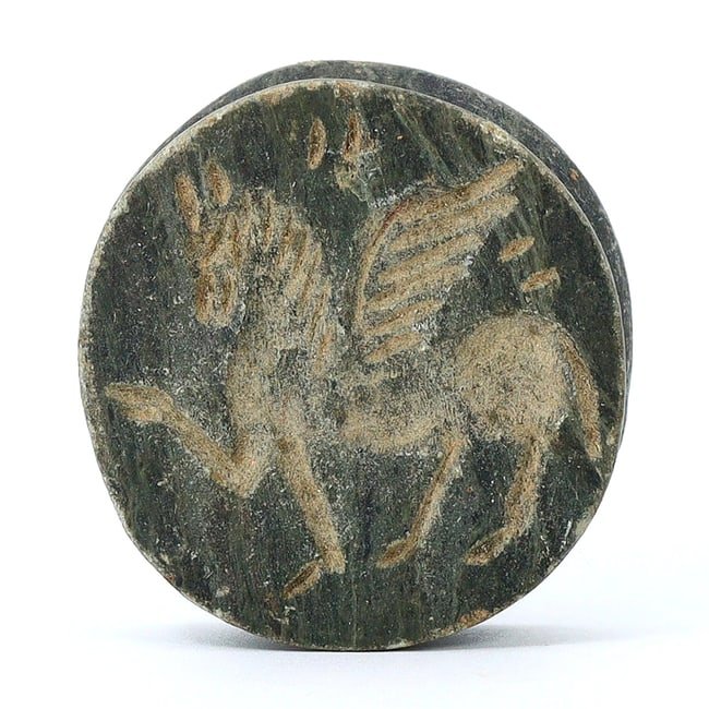 Greco-Bactrian Carved Disc, Winged Horse and Ibex, 300-100 BC: This intricately carved disc features a winged horse on one side and an ibex on the other, representing the Greco-Bactrian period, roughly from 300 to 100 BC. The disc's diameter is 4 cm, or 1.57 inch