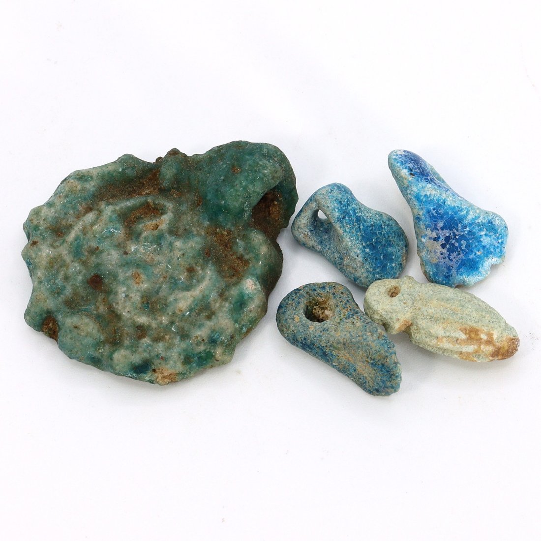 Egyptian Faience Amulets - Fist, Foot, Cylinder, Round (1000-800 BC): The offered lot comprises a selection of ancient Egyptian amulets, each ranging from approximately 1.4-3.7 cm (0.55-1.46 inches) in dimension. This collection embodies the mystical past of Egypt from 