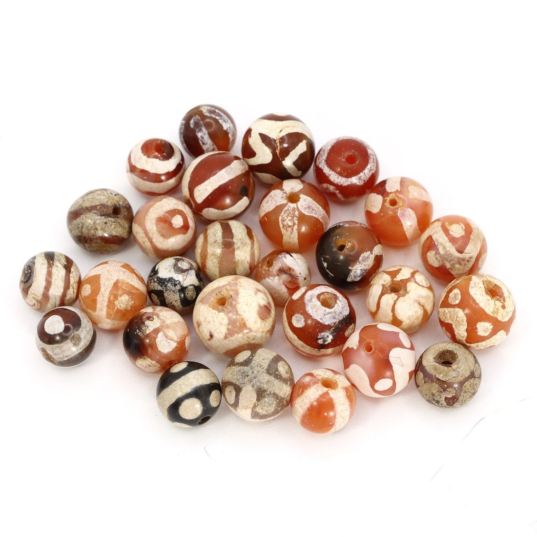 Group of 27 Medieval Himalayan Silk Road Tibetan Etched Carnelian Dzi Beads (6th-17th Century AD): These remarkable Tibetan etched carnelian dzi beads, totaling 27 in number, offer a captivating glimpse into the history of the Himalayan Silk Road during the period spanning from the 6th to the 17th 