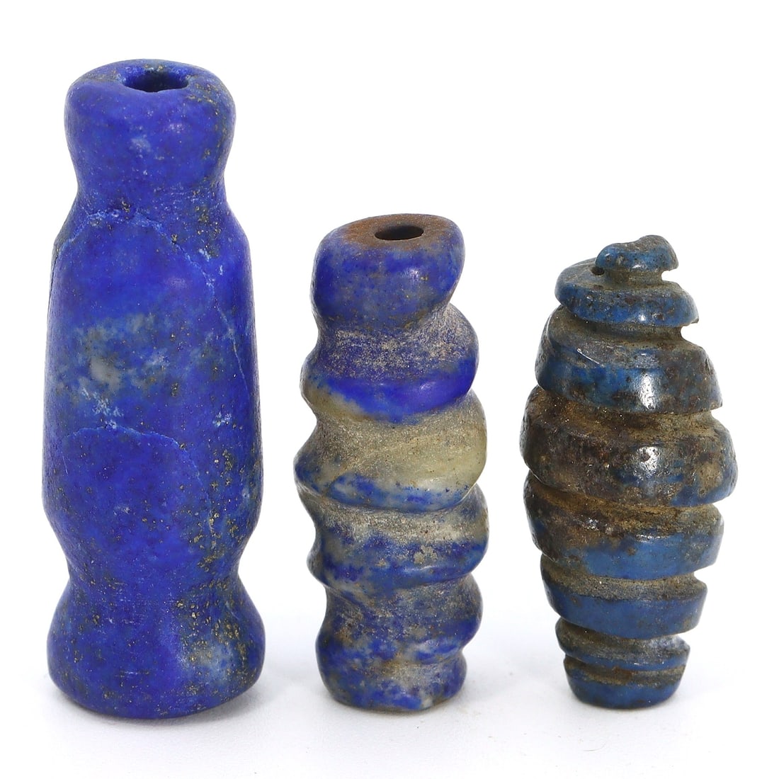 Sasanian to Islamic Era Ancient Swirl Form Lapis Lazuli Amulet Lot (224-750 AD): This lot comprises three ancient lapis lazuli amulets, showcasing a captivating swirl form design. These amulets span the transition from the Sasanian to the Islamic era, dating from 224 to 750 AD. Ea