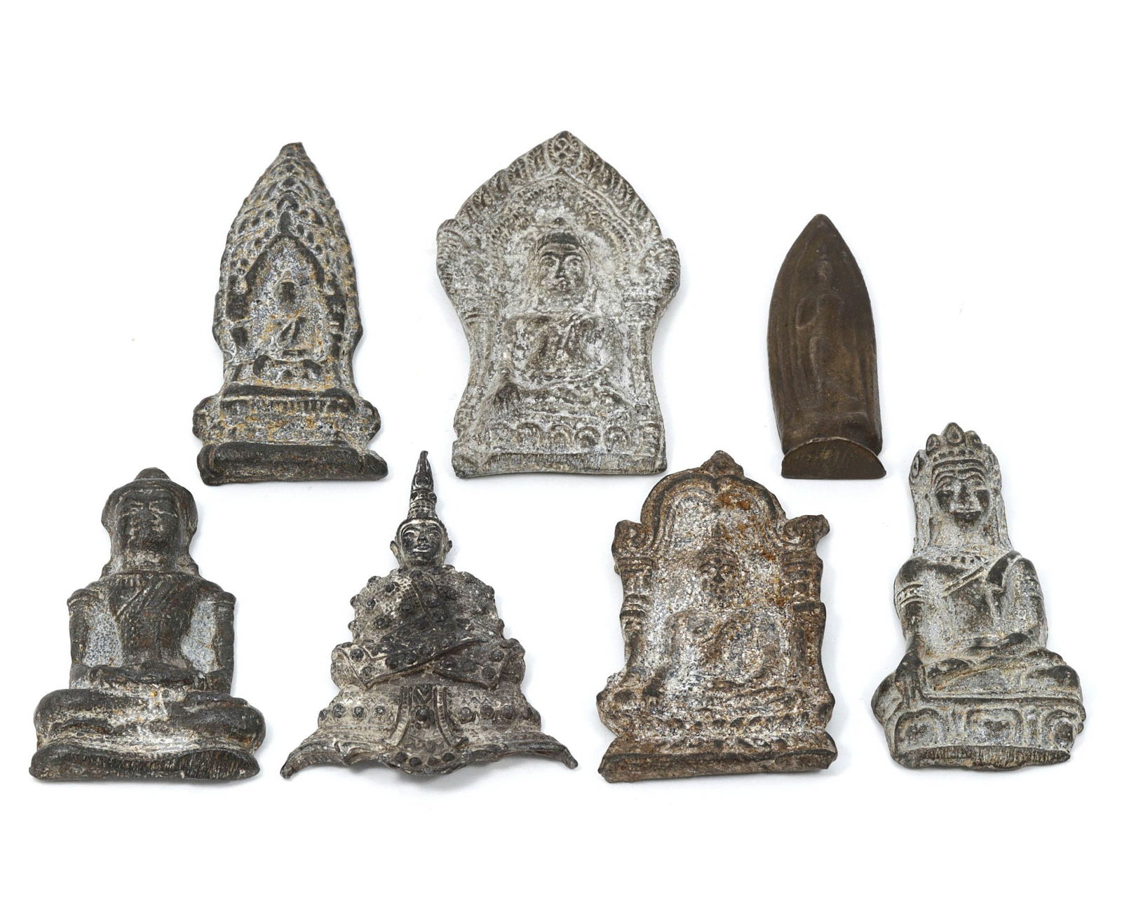 Group of 7 Tibetan & Himalayan Antique Votive Tablet Amulet, 17th-19th AD: This collection of antique votive tablet amulets originates from the Tibetan and Himalayan regions. Crafted from iron and lead, these amulets vary in dimensions, ranging from 5 to 6 cm each. In this s