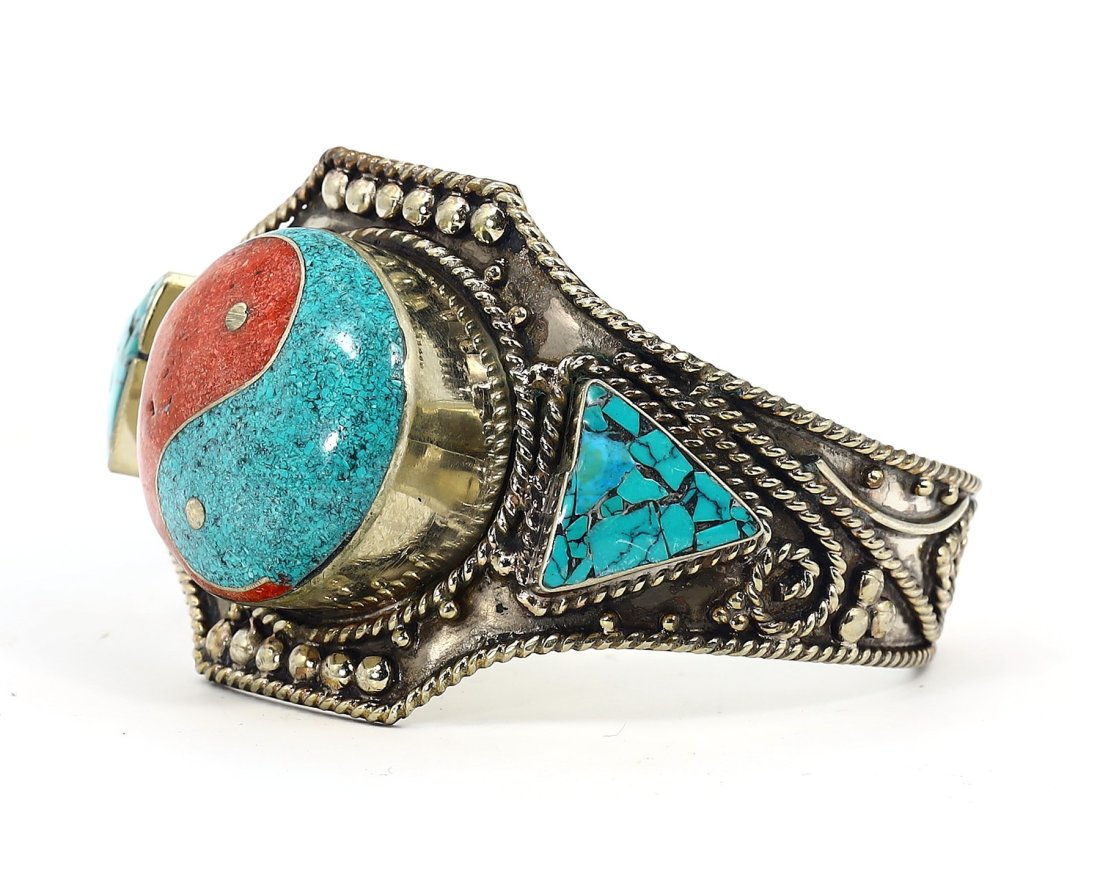 20th Century Tibetan Silvergilt Enamel Bangle with Turquoise & Coral Color Chips: This vintage Tibetan bangle bracelet, with a width of 7 cm or approximately 2.76 inches, is a vibrant example of 20th-century adornment. It is crafted from silvergilt, featuring rich turquoise-blue an