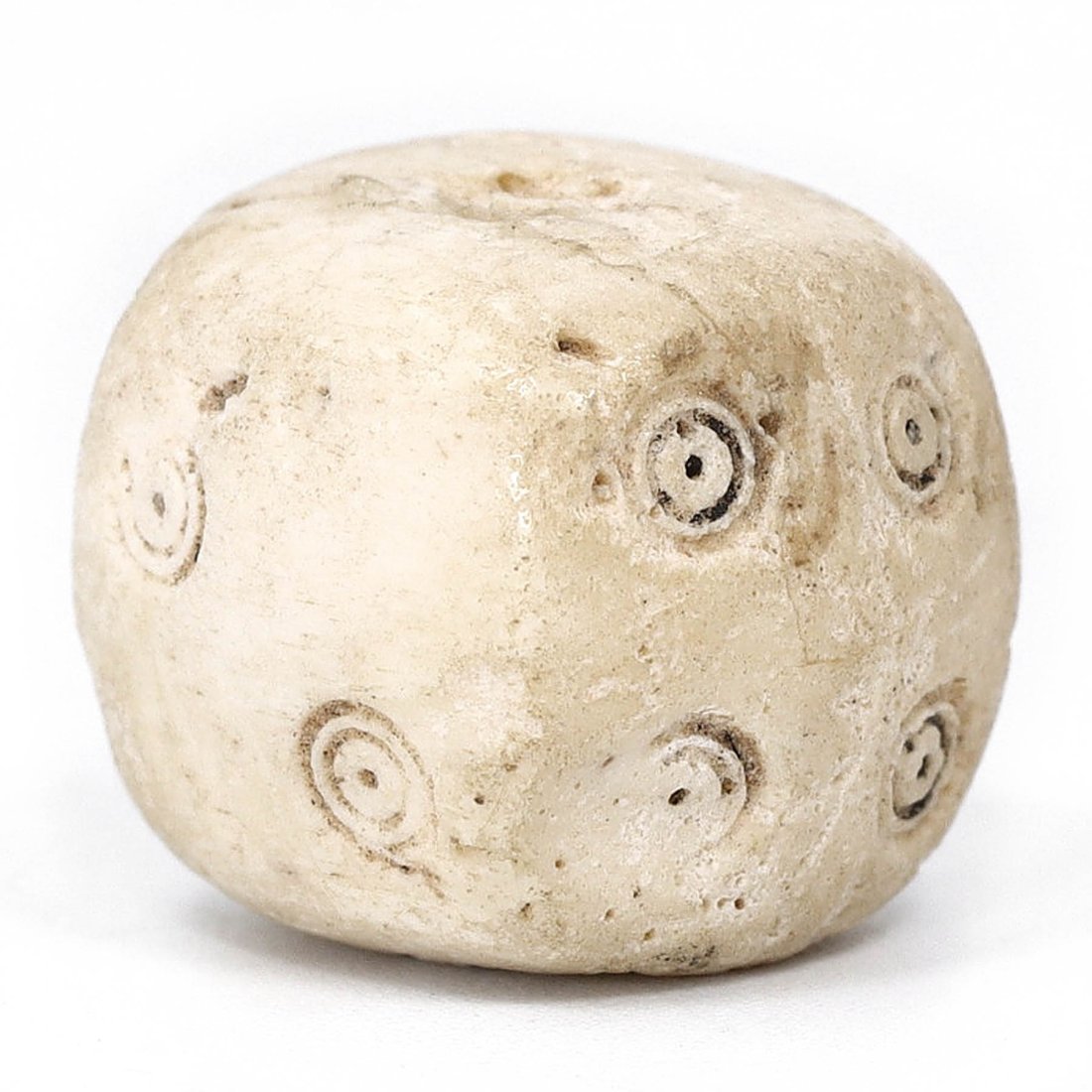 Ancient Roman Bone Dice, 1st-4th Century AD: A singular piece of gaming history: an ancient Roman bone dice, dating from the 1st to the 4th Century AD. The dice measures 14 mm by 13 mm by 12 mm, roughly translating to 0.55 inches by 0.51 inches 