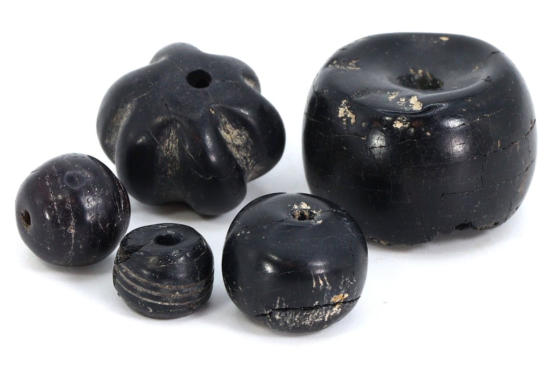 Ancient Persian Nishapur Jet Stone Amulets and Beads, 8th-10th Century: Offered here is a collection of five ancient Nishapur jet stone amulets and beads, their sizes ranging from 9 to 21 mm (approximately 0.35 to 0.83 inches). These pieces date back to the 8th-10th centu