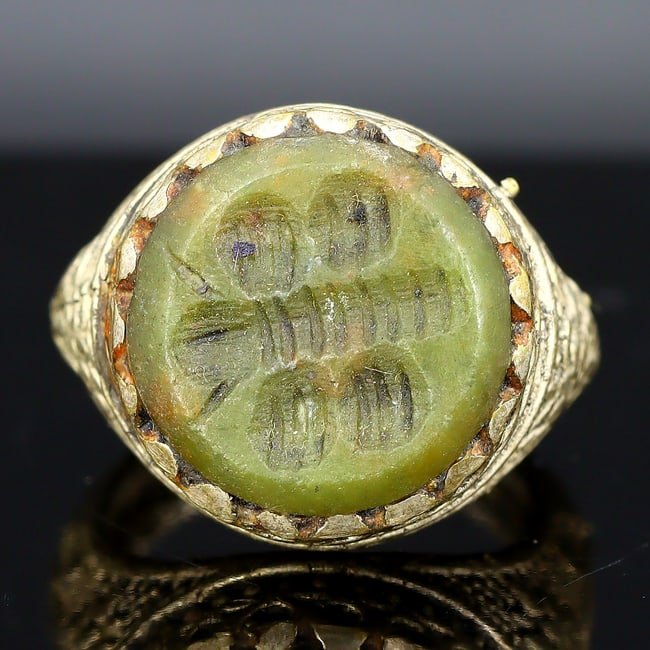 Mid-20th Century Islamic Silver-gilt Signet Ring with Green Gem Engraving, US Size 9: A splendid mid-20th century signet ring, a size US 9, showcasing the intricate beauty of Islamic art. The ring is composed of silver-gilt, a process that involves gold plating silver to achieve a lust
