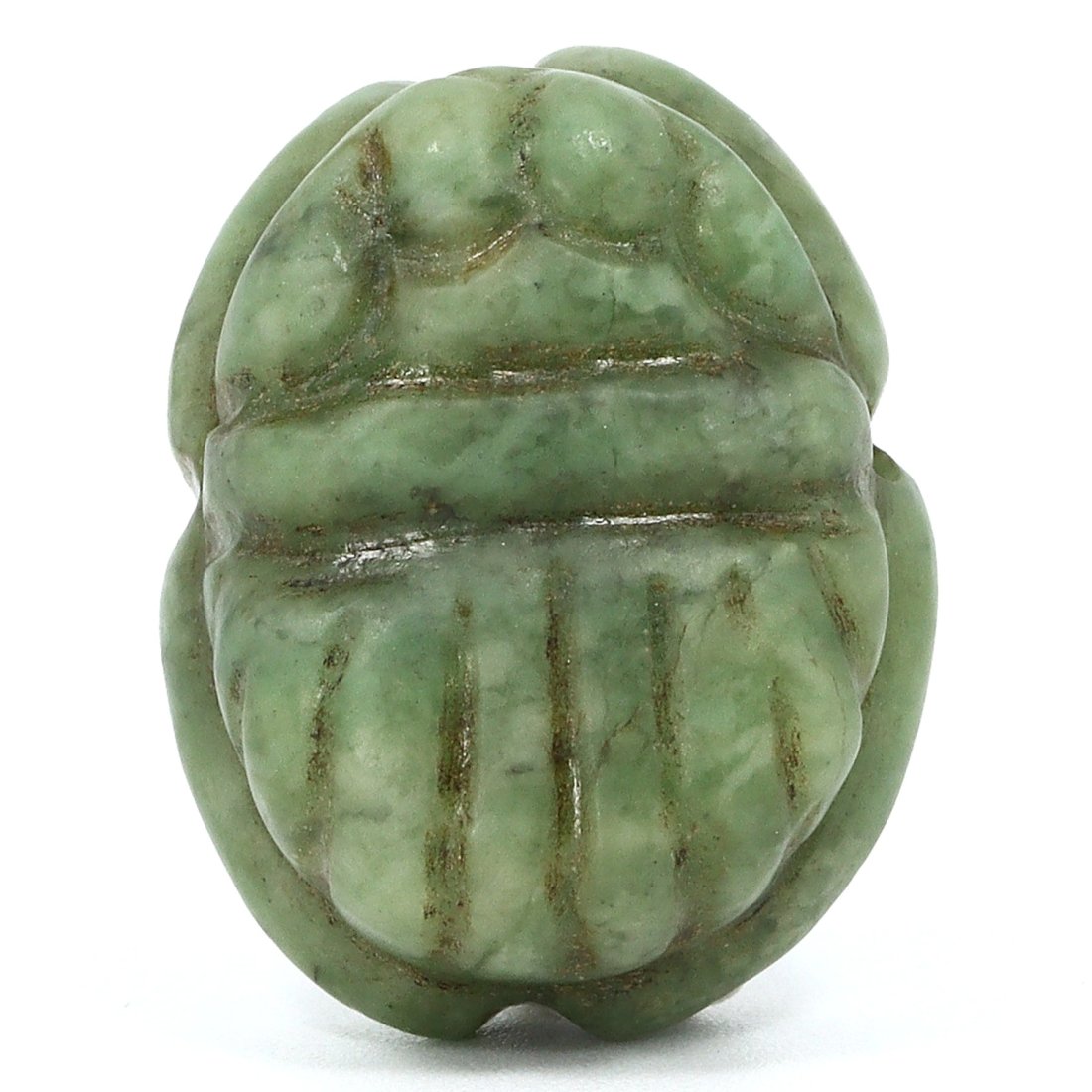 A Green Stone Scarab Amulet, New Kingdom, c. 1550-1077 B.C.: A striking example of ancient Egyptian craftsmanship, this green stone scarab amulet embodies both artistry and religious significance. Carved with meticulous attention to detail, the scarab represent