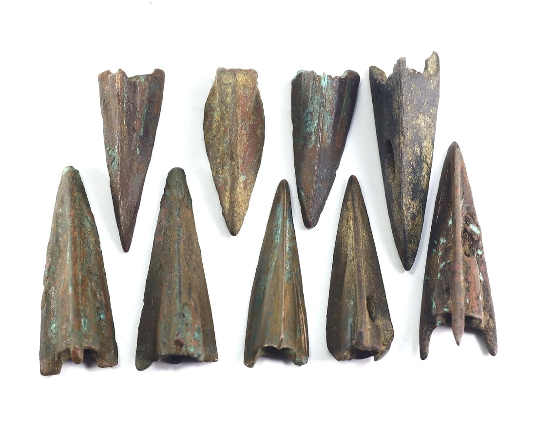 An Assemblage of Nine Bronze Arrowheads, Probable Hellenistic to Early Roman Periods: Spanning a diverse array of forms, this assemblage of nine bronze arrowheads includes examples with bifurcated tips and ridged blades, characteristic of the Hellenistic to early Roman periods. These v