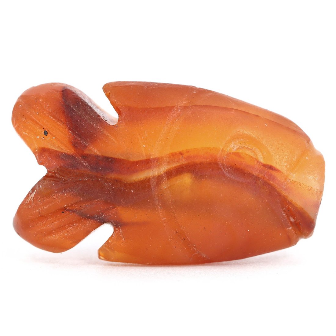 A Coptic Carnelian Fish Amulet, Egypt, Circa 4th-6th Century A.D.: This Coptic-era carnelian amulet, measuring a diminutive 2x1.4 cm, is exquisitely carved in the shape of a fish, a potent symbol in early Christian iconography representing Jesus Christ. The choice of